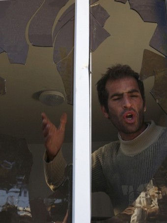 A Palestinian man shouts as he stands near a window shattered after Jewish settlers threw stones at it in the West Bank city of Hebron December 2, 2008. Jewish settlers and Palestinians threw stones in clashes on Monday that injured five in Hebron where Jews want to stop the eviction of 13 settler families, witnesses said. From Reuters Pictures by REUTERS.