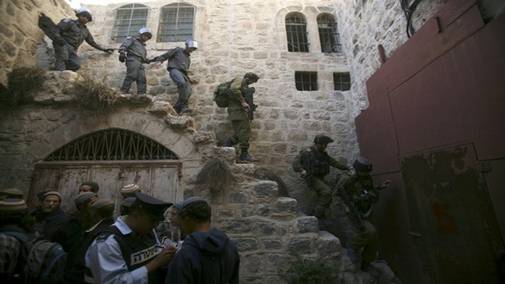 Israeli soldiers and police officers walk down the stairs after removing Jewish settlers from a previously evacuated house in the West Bank city of Hebron December 3, 2008. According to local media reports, dozens of Jewish settlers were removed by Israeli police on Wednesday from a house that had been evicted in 2006 following a High court order. From Reuters Pictures by REUTERS.